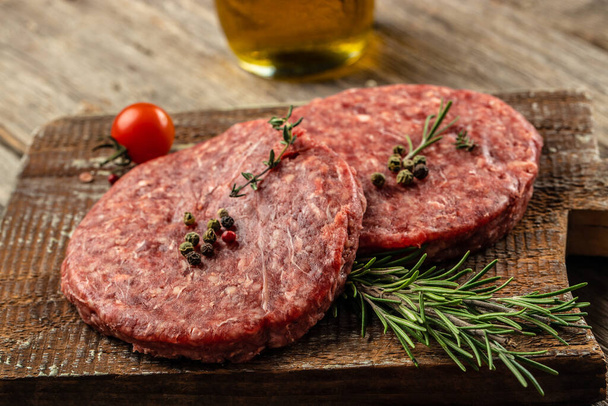 Сырое мясо говядины Мясо бургер котлеты на деревянной доске, питание рецепт фона. Закрыть, - Фото, изображение