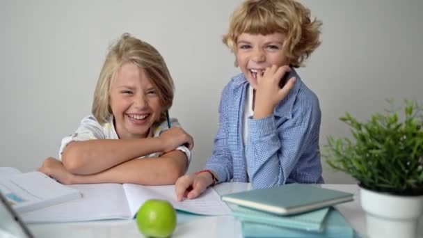 Általános iskolás fiú fiú lány testvérek tanul íróasztal, írás könyv és tabletta osztályban házi feladat információt szerezni tudás Vissza az iskolába. - Felvétel, videó