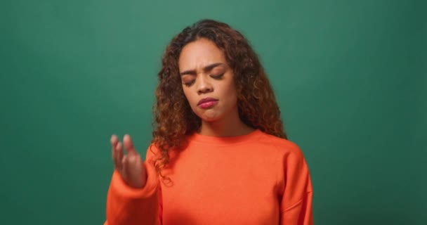 Young biracial woman covers face with hand, face palm, green studio background. High quality 4k footage - Footage, Video