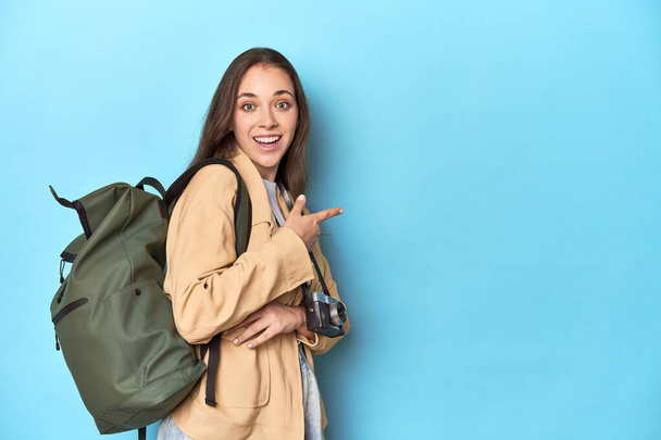 Cestující žena s vintage kamerou a batohem na modré. - Fotografie, Obrázek