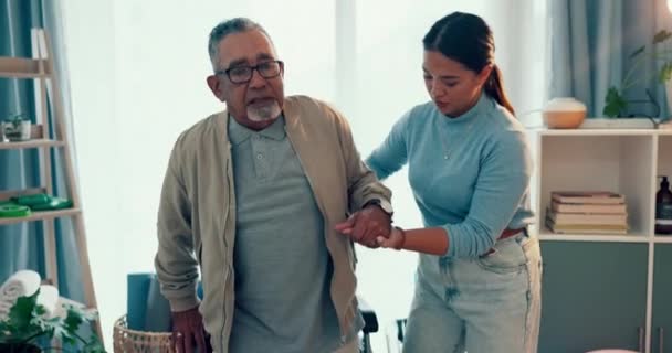 Woman, physiotherapist and helping wheelchair patient with walking or movement at the clinic. Female nurse or physio caregiver in elderly care with senior man or person with a disability at hospital. - Footage, Video