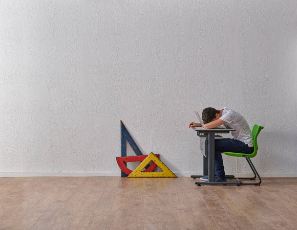 Teenage man student concept in the class, desk, chair, bookshelf and geometric tools on the grey wall background. - Fotó, kép