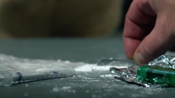 Narkoman przygotowujący linie heroiny do wstrzyknięć średnio powolny zoom shot selektywna ostrość - Materiał filmowy, wideo