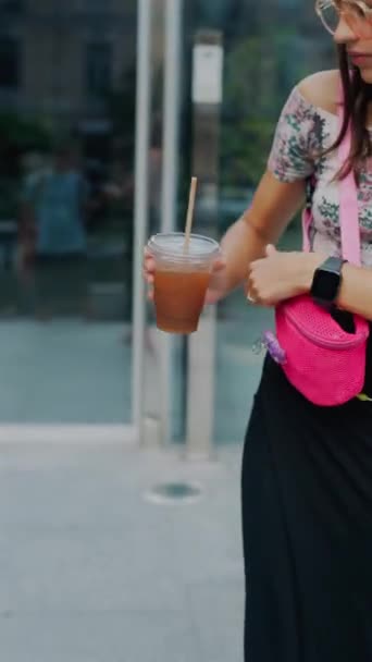 Uma jovem deslumbrante com um café e um smartphone na mão está correndo durante a hora mais movimentada do dia. Imagens 4k de alta qualidade - Filmagem, Vídeo