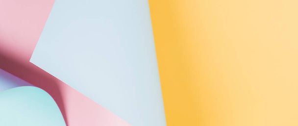 Abstract wave of yellow, pastel pink and light blue paper. Creative geometric curved solid color paper with light and shadows. Abstract geometry background with copy space. - 写真・画像