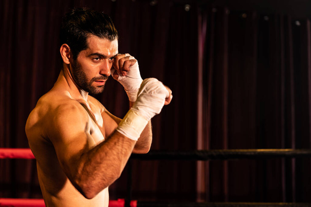 Boxing fighter pozowanie bez koszulki, biały bokser uderzyć jego gołą pięść i owinąć przed kamerą, agresywne stanowisko i gotowy do walki na ringu bokserskim. Impetus - Zdjęcie, obraz