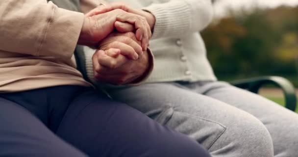 Relaks, empatia i wsparcie ze starą parą trzymającą się za ręce na ławce w parku dla społeczności, miłości i społeczności. Opieka, emerytura i charakter z zbliżeniem osób starszych w plenerze do współpracy. - Materiał filmowy, wideo
