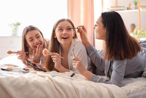 Young women doing makeup in bedroom - Foto, Imagen