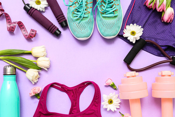 Quadro feito de sportswear com flores de primavera e equipamentos em fundo lilás - Foto, Imagem