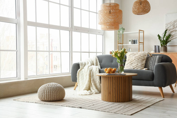 Sisustus tyylikäs olohuone kodikas sohva ja sohvapöytä lähellä iso ikkuna - Valokuva, kuva