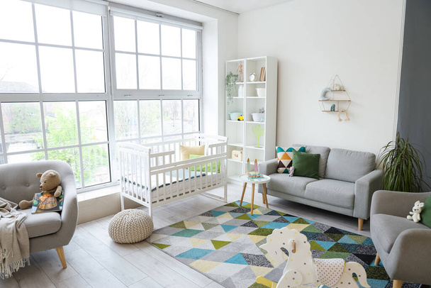 Stylish interior of children's room with baby bed and shelving unit - Photo, Image