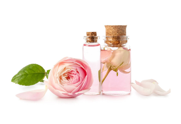 Bottles of cosmetic oil with rose extract and flower on white background - Fotografie, Obrázek