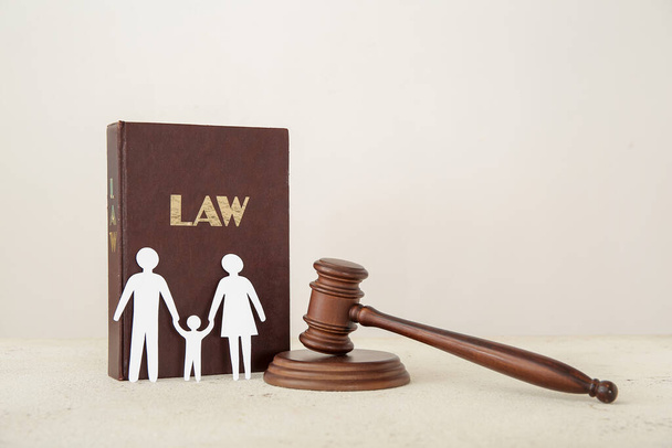 Rodinné postavy se soudcovskou kladívkem a právnickou knihou na grunge bílém stole - Fotografie, Obrázek