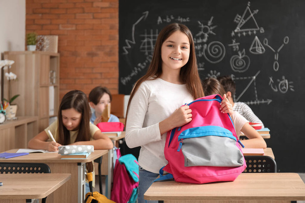 Kleines Mädchen mit Rucksack im Klassenzimmer - Foto, Bild