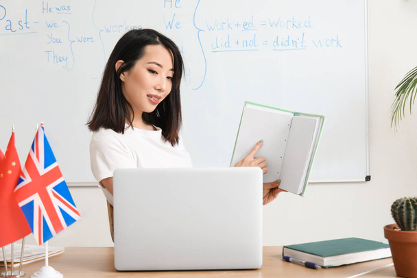 Female English teacher giving online grammar lesson in classroom - Foto, immagini