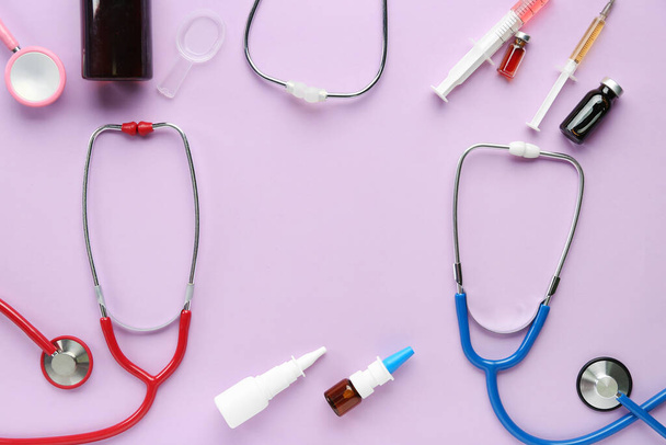 Medical stethoscopes, nasal drops and syringe on pink background - Fotoğraf, Görsel