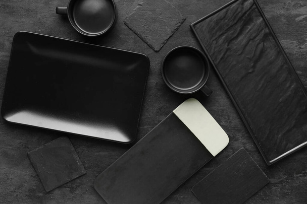 Tiszta edények és deszkák a fekete grunge asztalon - Fotó, kép