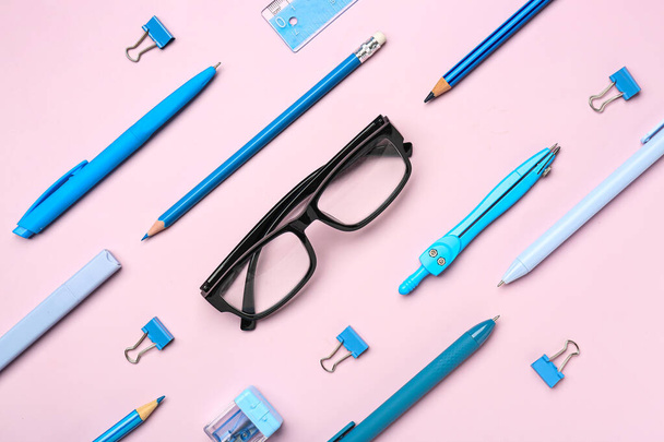 Стильные очки с канцелярскими принадлежностями на розовом фоне - Фото, изображение