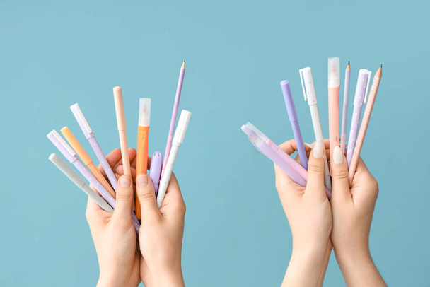 Female hands with school supplies on blue background - Foto, Imagem
