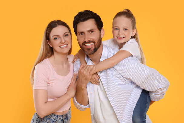 Portrait of happy family on orange background - 写真・画像