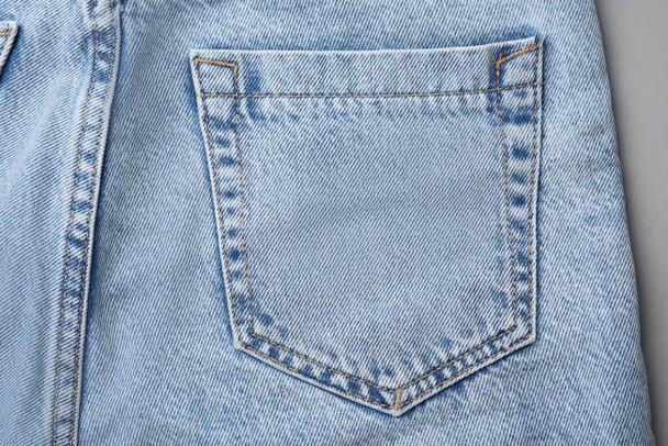 Jeans with pocket on grey background, top view - Fotoğraf, Görsel