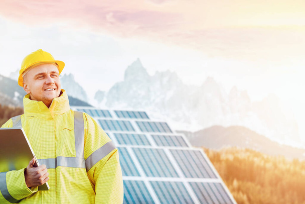 Towards a Sustainable Future. Engineer Amidst Solar Panels in the Majestic Mountains, Promoting Renewable Energy and Nature Conservation. Industrial concept in beautiful nature concept. - Photo, Image