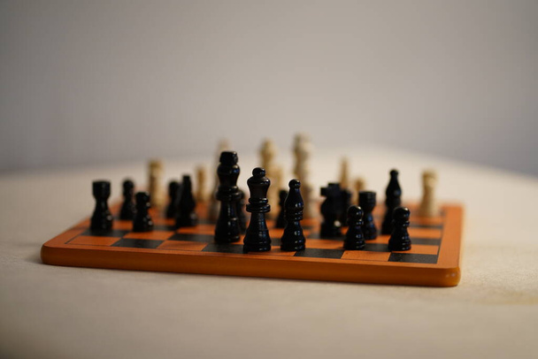 Dos equipos de ajedrez uno delante del otro en el tablero de ajedrez. fondo blanco. Foto de alta calidad - Foto, Imagen