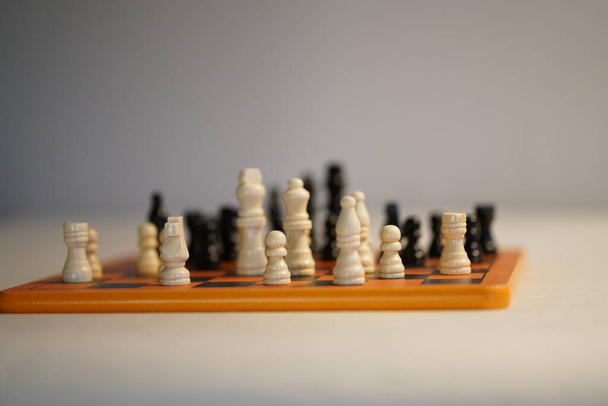 Duas equipas de xadrez uma à frente da outra no tabuleiro de xadrez. fundo branco. Foto de alta qualidade - Foto, Imagem