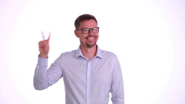 Young businessman man on white background showing victory sign and smiling broadly. Approval success gesture - Footage, Video