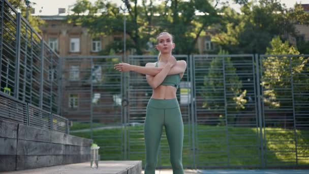 Sterke atletische vrouw stretching opwarmen voor het uitvoeren van outdoor - Video