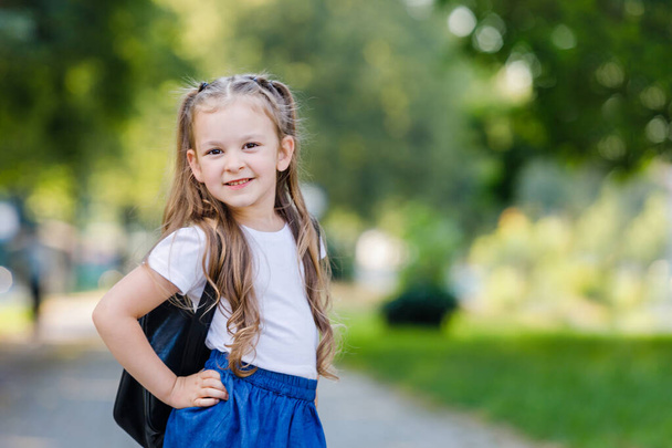 Портрет щасливої дівчини зі шкільною сумкою. Маленька щаслива школярка ходить до школи, повертається до школи, концепція освіти. Початок первинного року. Високоякісна фотографія. Простір копіювання. - Фото, зображення