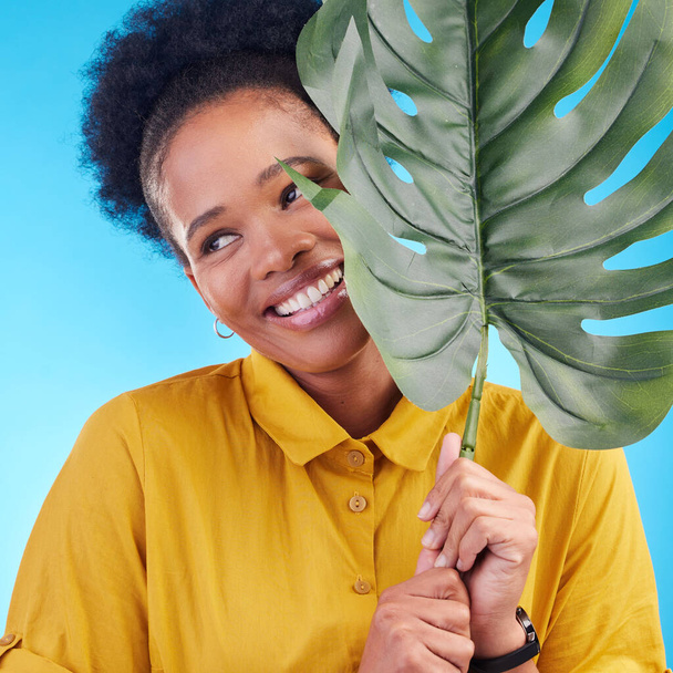 Divat, boldog és fekete nő növény kék háttér kozmetikumok, smink és a szépség. Természet, stúdió és női személy monstera levél ökológiai, természetes és méregtelenítő termékek wellness. - Fotó, kép