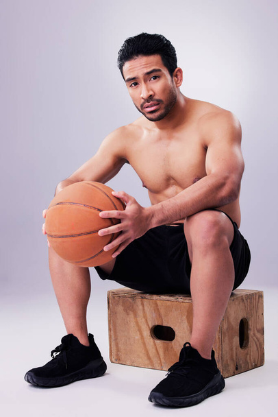 Porträt, Fitness und Basketball mit einem Mann auf einer Box im Studio auf grauem Hintergrund für das Training oder ein Spiel. Bewegung, Workout oder Denkweise und ein junger männlicher Sportler, der einen Ball mit Fokus hält. - Foto, Bild