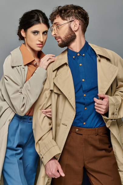 outerwear, couple in trench coats, autumn fashion, stylish man and woman, grey background, fall - Photo, Image