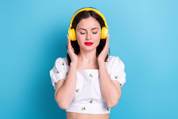 Photo of pretty adorable lady wear white blouse closed eyes enjoying songs isolated blue color background. - Zdjęcie, obraz