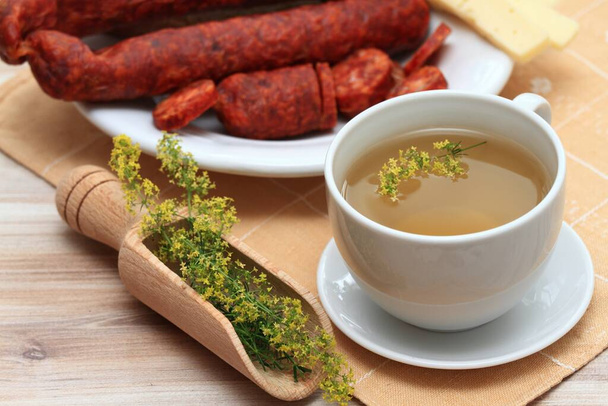 Herbal tea from herb Galium verum, also known as  lady's bedstraw or yellow bedstraw and sausage. Traditional medicinal herb reduces appetite and  helps to lose weight. - Photo, Image