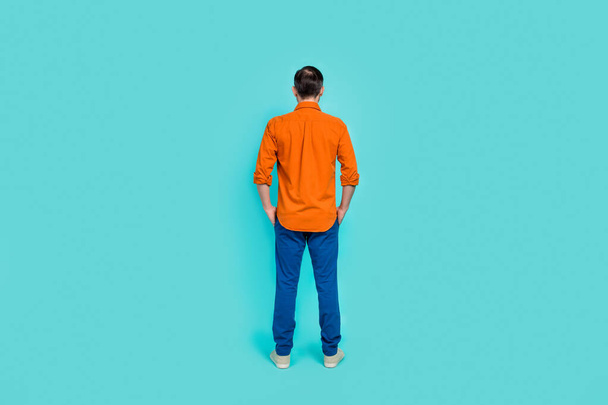 Full length size photo of formalwear businessman wear orange shirt with blue denim jeans hands pockets isolated on cyan color background. - Fotografie, Obrázek