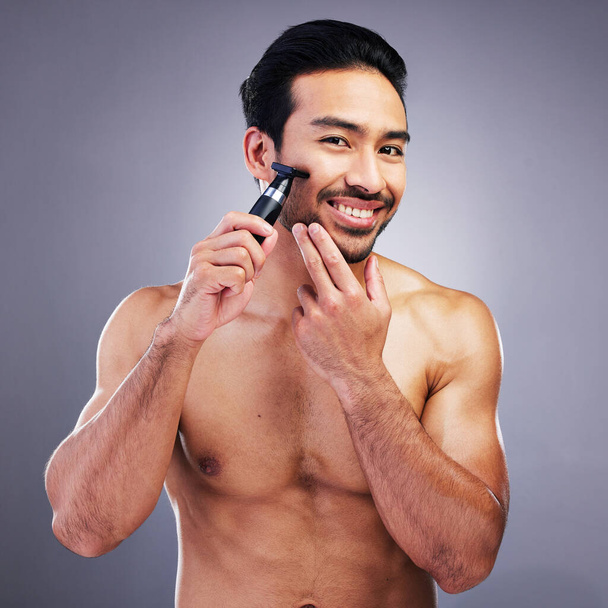 Beard hair trimmer, portrait or happy man with bathroom routine, grooming or morning smile for shaving skincare. Face cleaning, facial growth maintenance or studio person happiness on gray background. - Fotó, kép