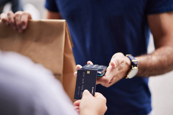 Hands, paper bag and delivery with credit card, payment and fintech for remote customer experience. Man, woman and package for lunch, e commerce and fast food shipping with supply chain employee. - Foto, Imagem