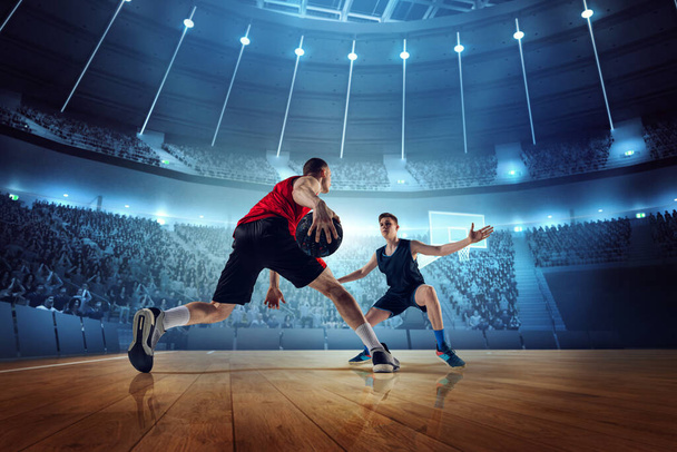 Motivated and competitive young men, basketball players in motion during match, game playing at 3D arena with flashlights. Concept of professional sport, competition, action, hobby, game. - Fotoğraf, Görsel