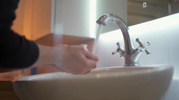 自宅の浴室で顔を洗う若い男。衛生概念 - 映像、動画