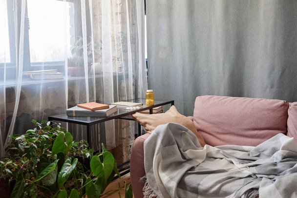 Poziomy nie ma osób ujęcie strychu salon wnętrze w nowoczesnym apartamencie z sofą, biurko i butelka tabletek na nim - Zdjęcie, obraz