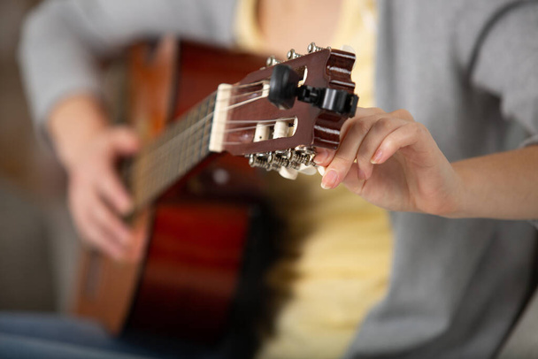cropped view of woman tuning a guitar - Foto, immagini