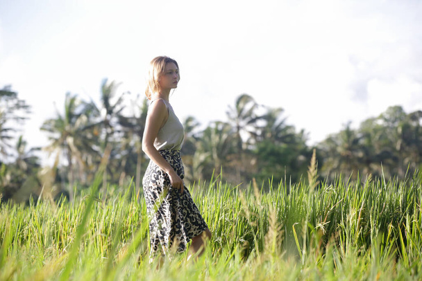 Outdoor fashion portrait of young woman in the rice field on the tropical island, natural sunlight. Concept of freedom, travel, enviroment, connecting with nature - Fotografie, Obrázek