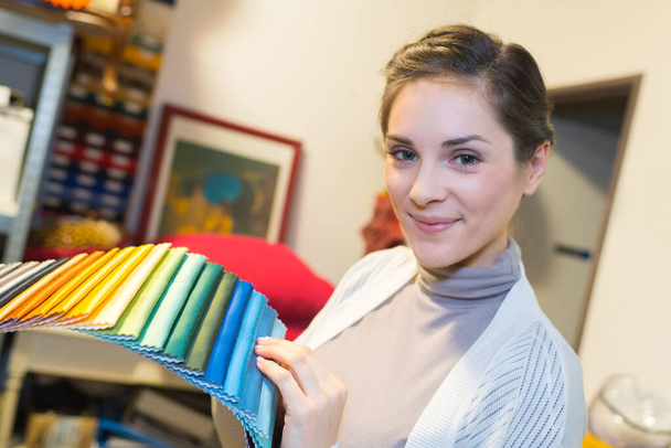 жінка тримає кольорові зразки тканини - Фото, зображення