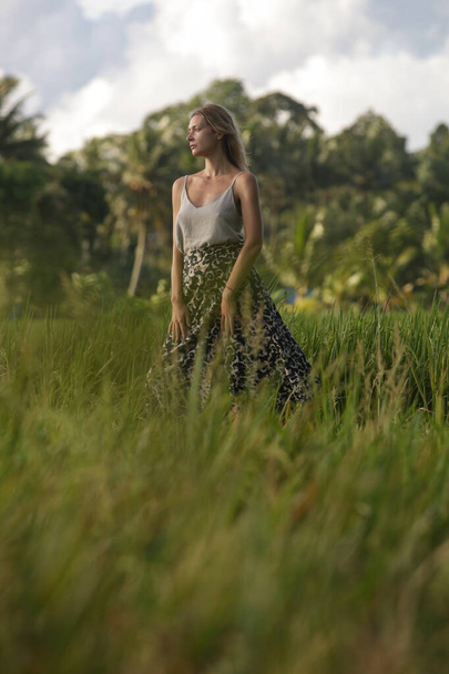 Portrait de mode en plein air de jeune femme dans la rizière de l'île tropicale, lumière naturelle du soleil. Concept de liberté, de voyage, d'environnement, de connexion avec la nature - Photo, image