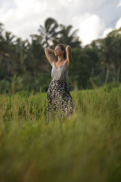 Outdoor fashion portrait of young woman in the rice field on the tropical island, natural sunlight. Concept of freedom, travel, enviroment, connecting with nature - Foto, Imagem