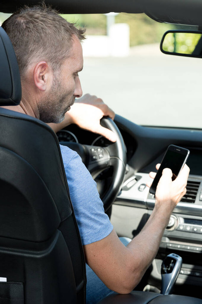 man holding the phone in the car - Foto, Imagen
