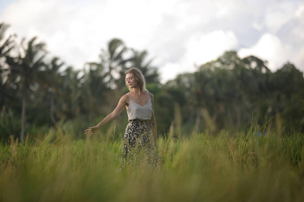Outdoor fashion portrait of young woman in the rice field on the tropical island, natural sunlight. Concept of freedom, travel, enviroment, connecting with nature - Photo, Image