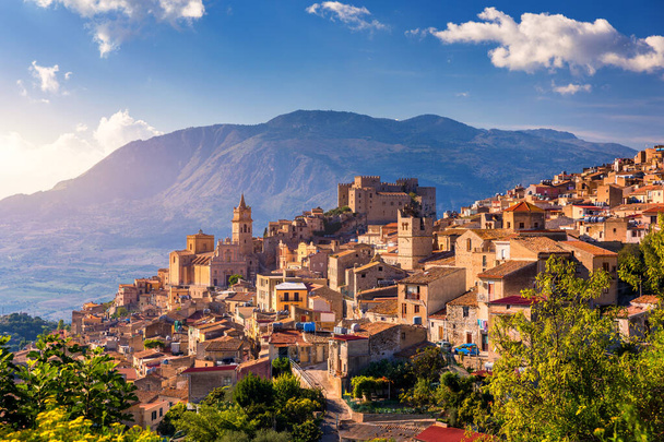 Caccamo na Sycylii. Średniowieczne włoskie miasto z zamkiem Norman w górach Sycylii, Włochy. Widok na miasto Caccamo na wzgórzu z górami w tle, Sycylia, Włochy. - Zdjęcie, obraz